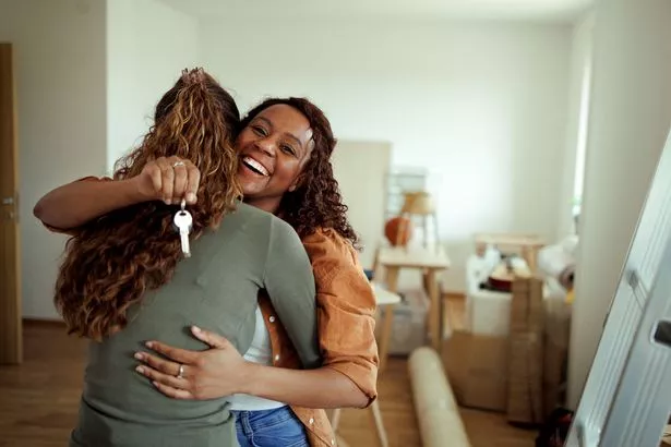 couple hugging in their new apartment, one is holding house keys