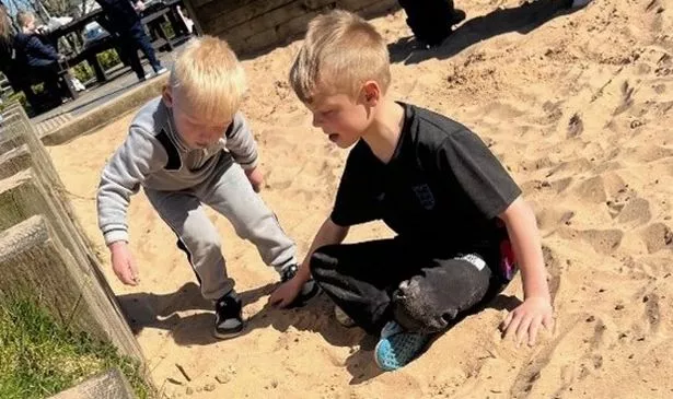 Oliver and Charlie Sanderson playing in the sand