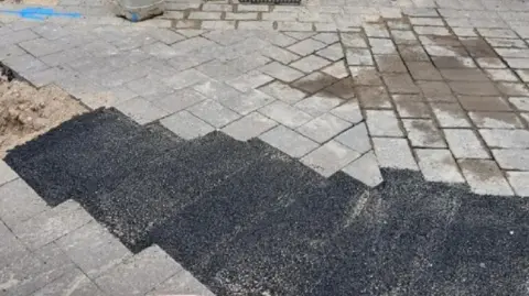 Goole Civic Society Black tarmac fills the gaps in the pavement, with the original grey paving stones surrounding it.