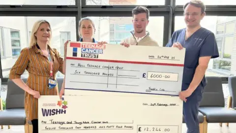 Hull University Teaching Hospitals NHS Trust Four people hold up two giant cheques, one to Hull Teenage Cancer Trust for £6,000 and the other to the Teenage and Young Adult Cancer Unit for over £12,000.