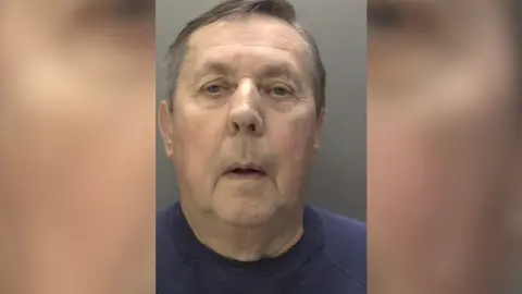 Humberside Police A police headshot of a man wearing a navy t-shirt looking at the camera. He has short grey hair.