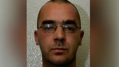 Humberside Police A man in his 20s, with close-cropped dark hair, thick eyebrows and metal-rimmed glasses, looking at the camera.