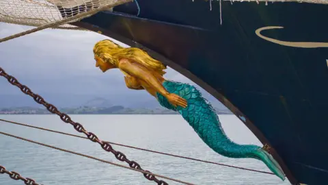 Getty Images A wooden mermaid statue on the bow of a ship