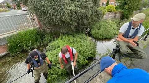 BBC Four men carrying out the rescue of the fish.