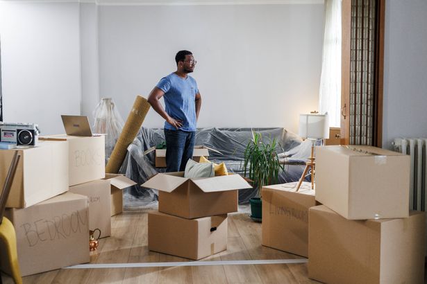 In this tender moment, a young man takes a break from packing, lost in thoughts and nostalgia for his soon-to-be former home. The room is filled with a sense of quiet reflection and the weight of memories as he grapples with the emotional toll of leaving.