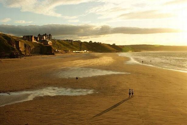 Evening sun on whitby beach with sand blowing