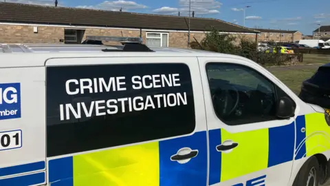 BBC A police van parked in front of a property with Crime Scene Investigation written on it.