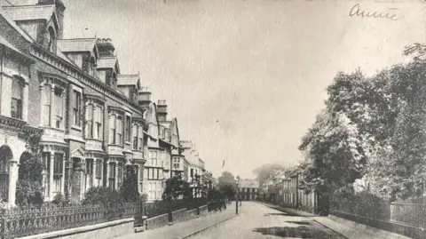 Postcard Traders Association A black and white postcard image of a street lined with large townhouses. 