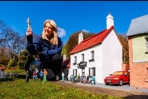 Rachel Hill, owner of Bondville Model Village, inspects some of the models.
