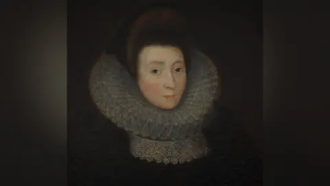 Burton Agnes Hall A painted portrait of Anne Griffith. She has dark brown hair in an Elizabethan-era updo style. She has a large, white ruffled collar on and is wearing a black dress. She is pale with brown eyes.