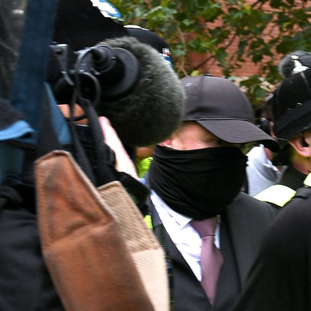 Robert Bush leaves Hull Crown Court surrounded by police after making pleas to 67 charges in connection with the investigation into Legacy Independent Funeral Directors