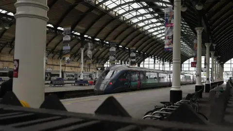 An image of the interior of Hull Paragon Station, platforms and benches are visible underneath a sweeping curved and partially glazed roof