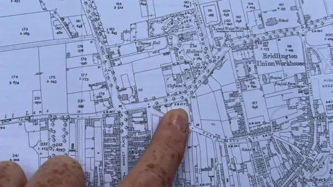 Amanda White / BBC An index finger pointing to a road marked Short Lane on a 1911 Ordnance Survey map