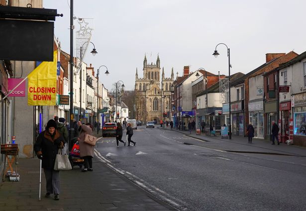 Selby, UK - January 17, 2025: People shopping on the High Street on a January weekend, including a closing down sign in the foreground, Selby, Yorkshire.