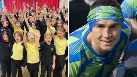 BBC/PA The image is split into two sections. On the left, a large group of schoolchildren wearing yellow and black uniforms stand indoors in front of a bright red curtain, raising their hands enthusiastically. On the right, a close-up of Kevin Sinfield wearing a blue and green patterned athletic shirt and a green headband.
