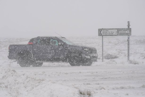 CASTLETON, UNTED KINGDOM - NOVEMBER 19: A car drives through heavy snow on the North Yorkshire Moors National Park on November 19, 2025 in Castleton, United Kingdom. The Met Office have issued amber and yellow weather warnings for snow and ice across the UK as some parts have already been hit by heavy snowfall. (Photo by Ian Forsyth/Getty Images)