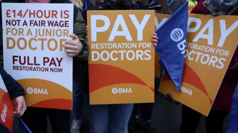 Reuters A group of signs being held by resident doctors striking last July in their calls for pay restoration