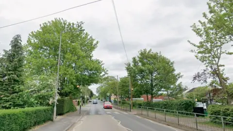 Google A Google street view image of Welton Road, Brough. The road is lined by green trees and bushes. A pedestrian crossing is visible as well as a petrol station in the distance.