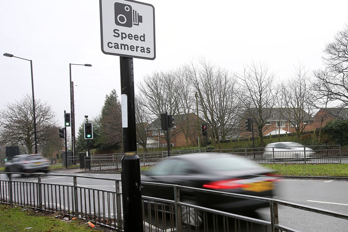 A blurred car passes a speed camera advisory sign; the Police and Crime Commissioner has announced a new grant scheme to help the likes of parish and town councils get a camera in their area
