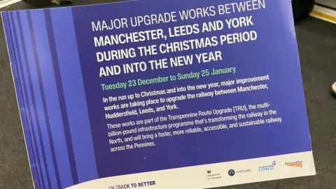 BBC/Seb Cheer A leaflet reading: MAJOR UPGRADE WORKS BETWEEN MANCHESTER, LEEDS AND YORK DURING THE CHRISTMAS PERIOD AND INTO THE NEW YEAR
Tuesday 23 December to Sunday 25 January
In the run up to Christmas and into the new year, major improvement works are taking place to upgrade the railway between Manchester, Huddersfield, Leeds, and York.
These works are part of the Transpennine Route Upgrade (TRU), the multi-billion-pound infrastructure programme that’s transforming the railway in the North, and will bring a faster, more reliable, accessible, and sustainable railway across the Pennines.
