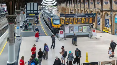 Getty Images Platform six at York Railway station, with a Northern train at the platform and people walking around the concourse.