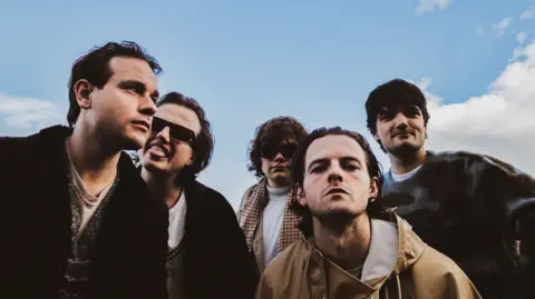 Tidetied Five males, all with dark, pose in front of the camera. 