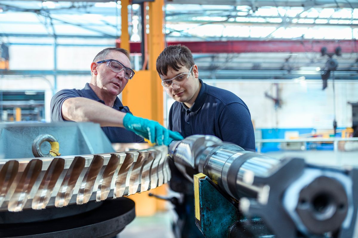 Apprentice engineer receiving mentoring in a factory (file picture)