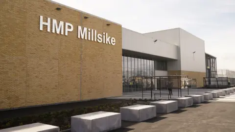 Danny Lawson / PA Media The outside of the jail. Light brown brickwork to the left with the sign HMP Millsike in large white letters, while to the right is a glass-front entrance.