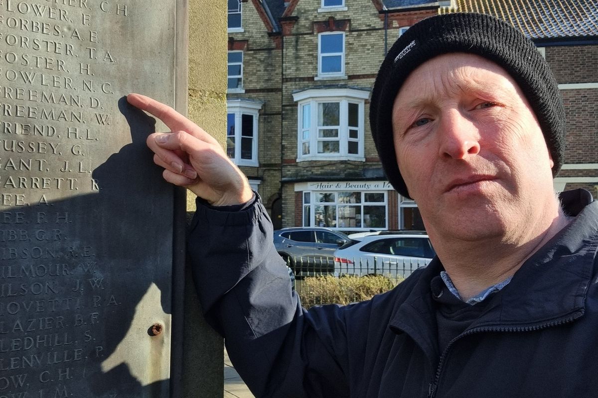 Author Richard M Jones points out Norman Charles Fowler's name on Bridlington War Memorial