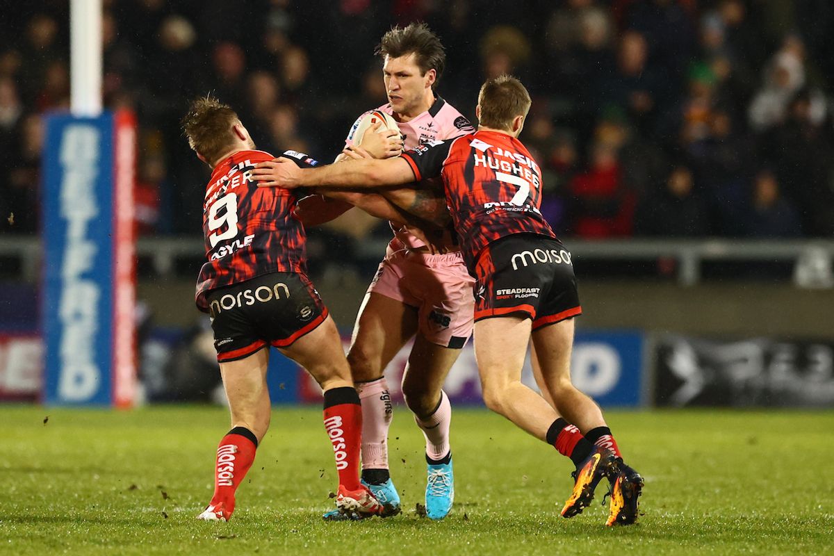 Hull FC’s Tom Briscoe is tackled by Salford Red Devils' Brad Dwyer and Toby Hughes