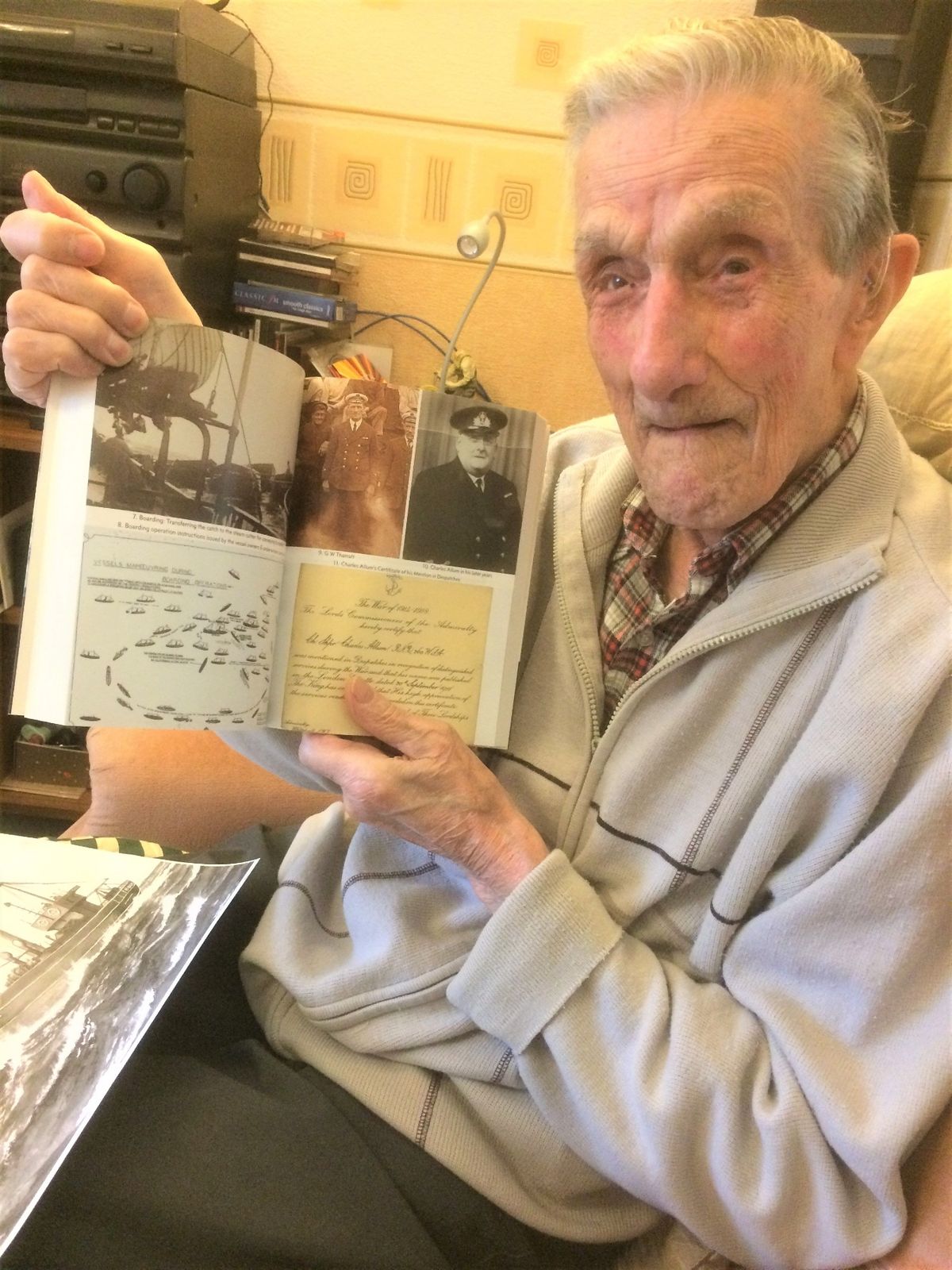 The late Eric Tharratt with a copy of Viola: The Life and Times of a Hull Steam Trawler showing his father George William Tharratt, a former skipper of the trawler