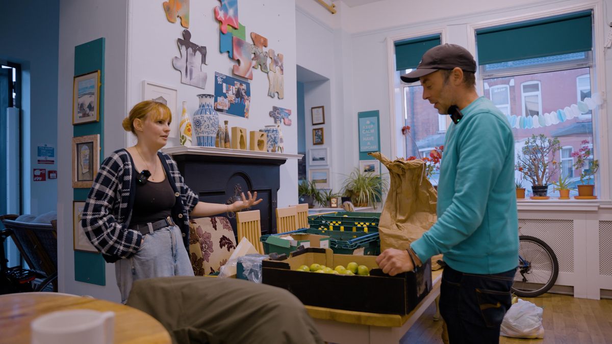 Matt Golding being shown the produce of the food club by Lauren from Cooperation Hull