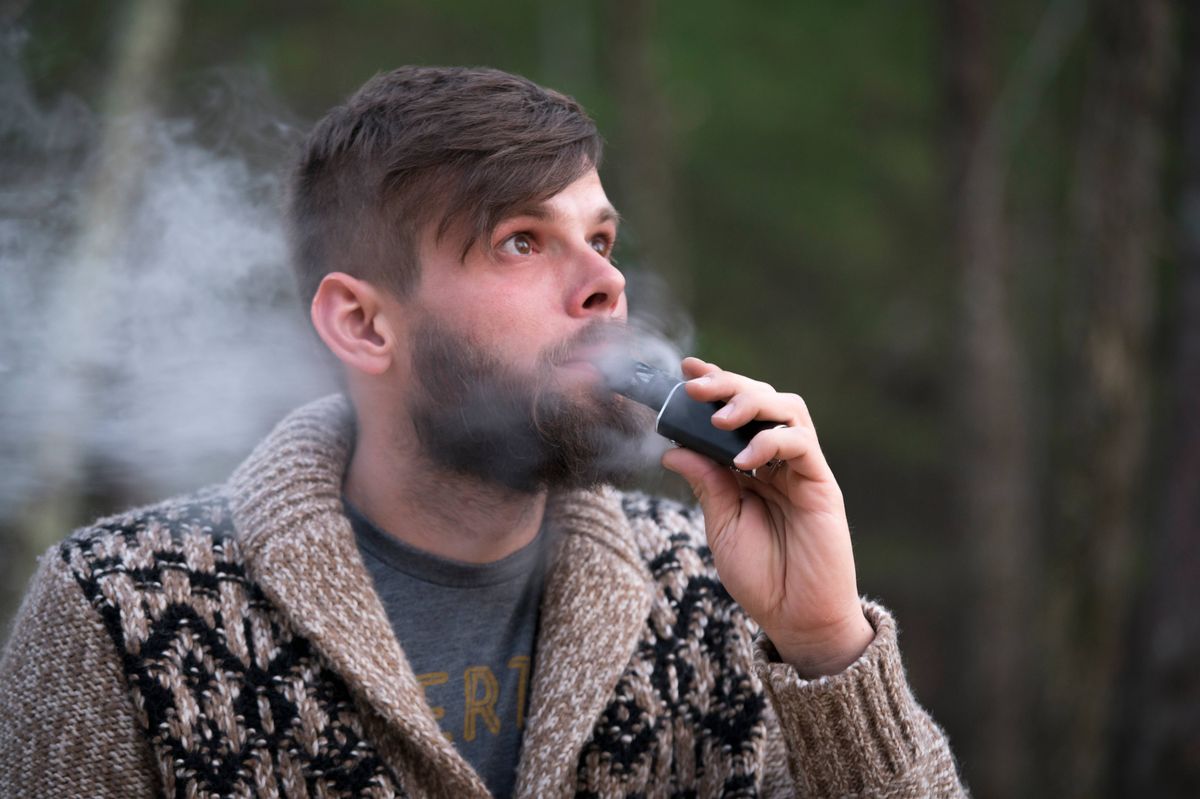 medium shot of Man exhaling vapor.