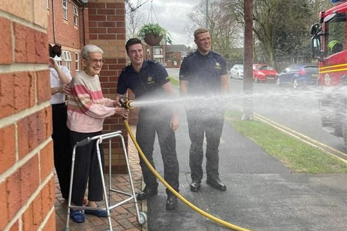 You can spray that again... a resident of Windsor Court care home in Goole tries out the fire hose during a visit by firefighters stationed at Goole Fire Station