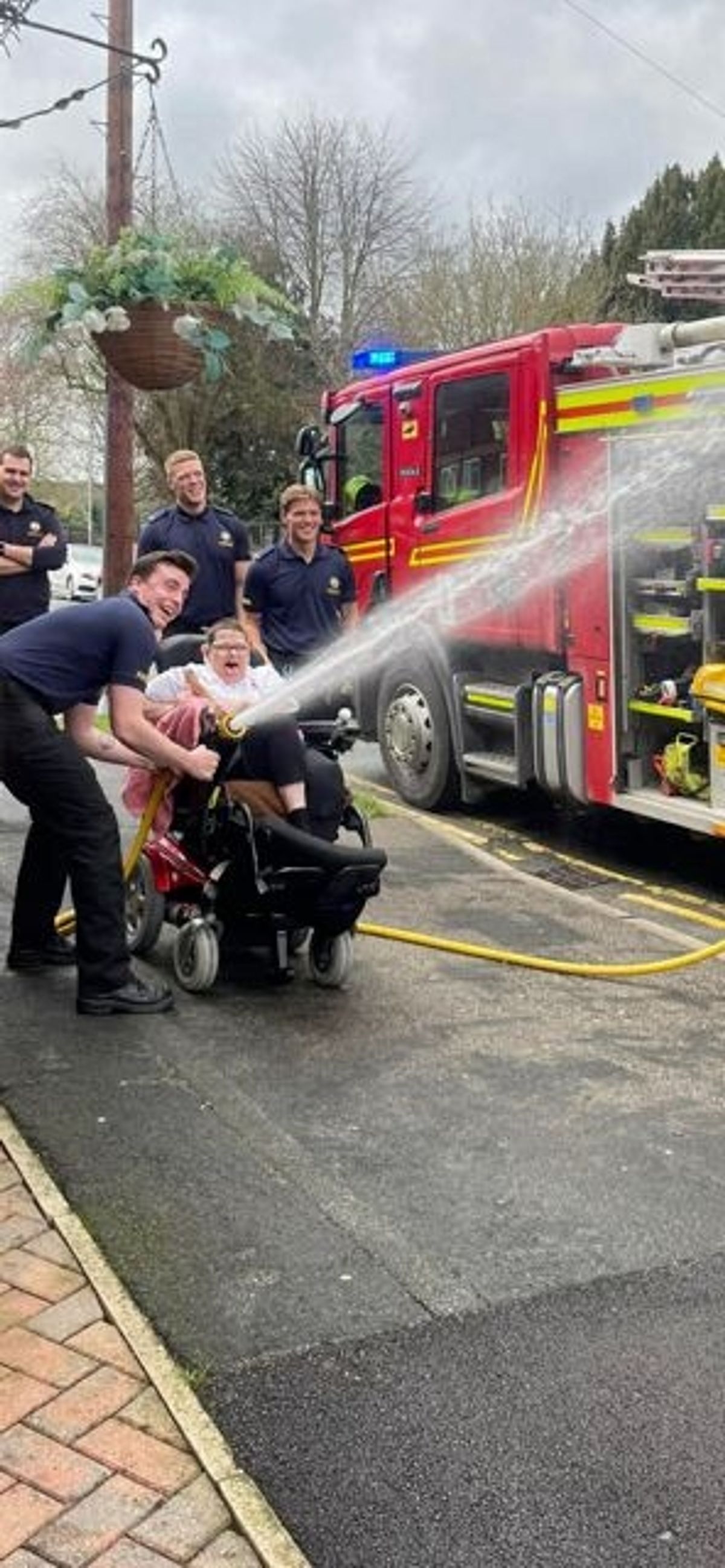 A resident of Windsor Court, Goole, with Humberside Fire & Rescue Service, spraying the fire hose