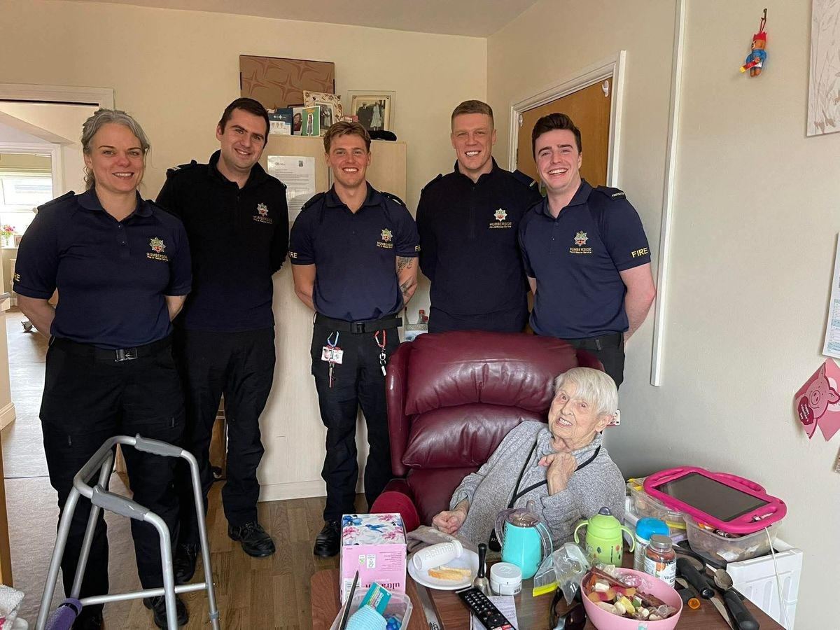 A resident at Windsor Court care home with Humberside Fire & Rescue Service personnel