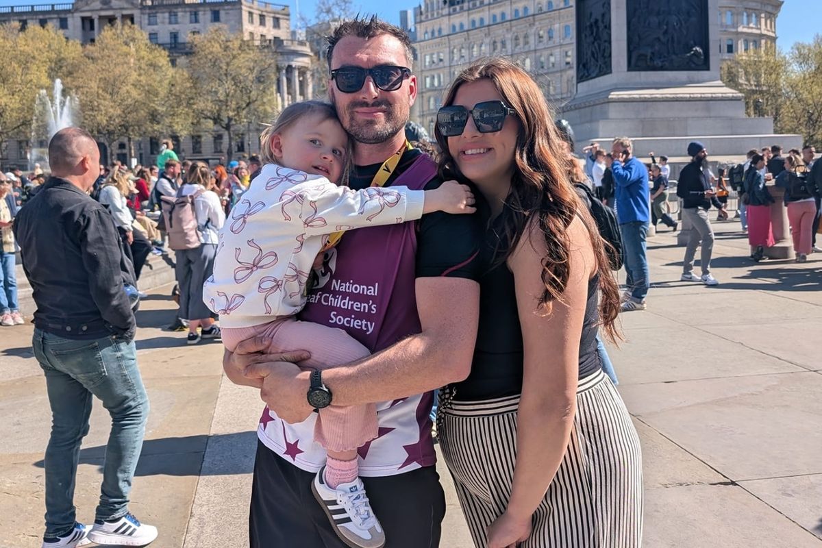 Abigayle Henderson with her partner Joe Kidd and Darcy in Trafalgar Square after Joe completed the London Marathon for the National Deaf Children's Society.