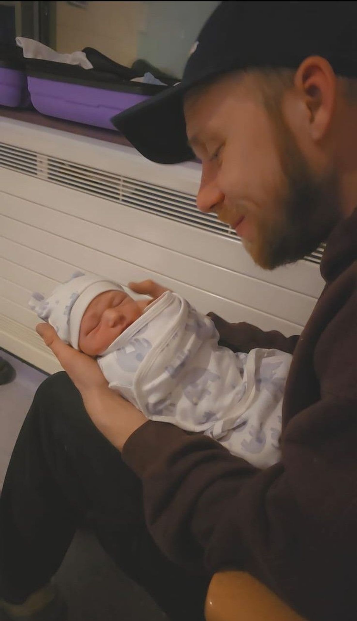 New dad TJ Holland cradles Oliver