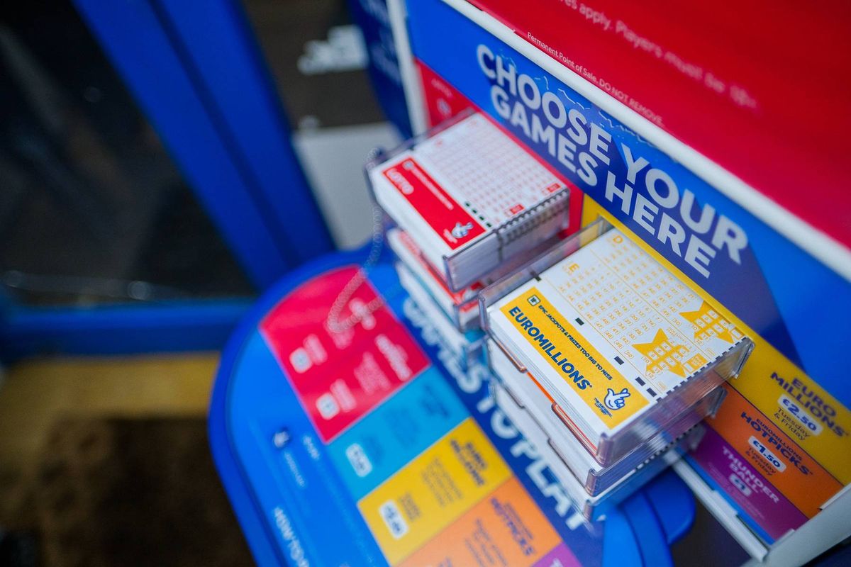A close-up view of a collection of assorted merchandise stacked on a blue surface, prominently featuring a red and white box with the text "CHOOSE YOUR GAMES HERE" displayed prominently.