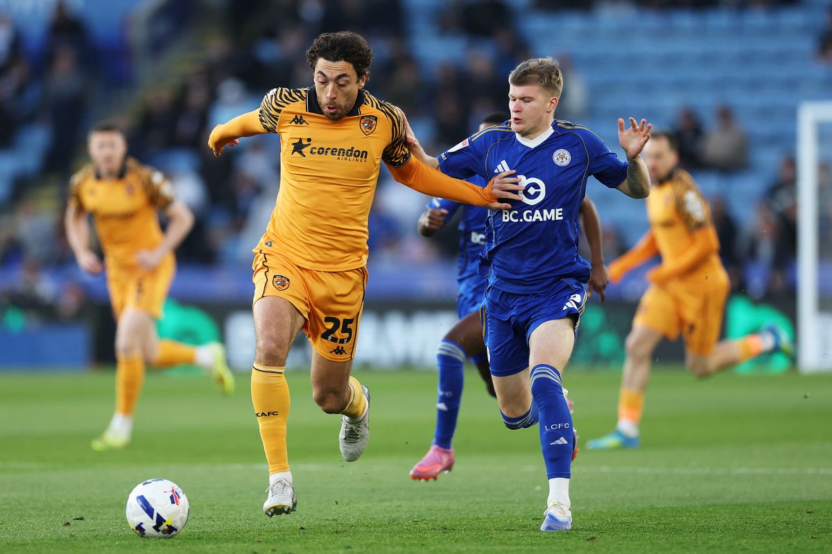 Matt Crooks of Hull City runs with the ball while under pressure from Jordan James of Leicester City
