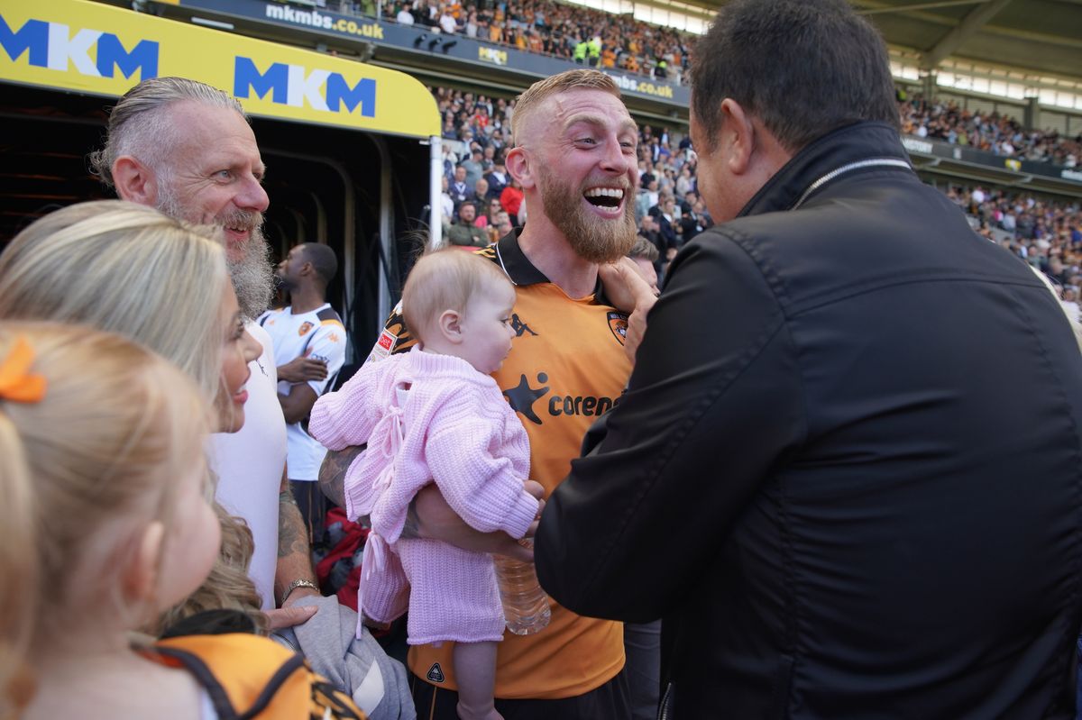 Hull City's Oli McBurnie holds his daughter as he celebrates with Acun Ilicali