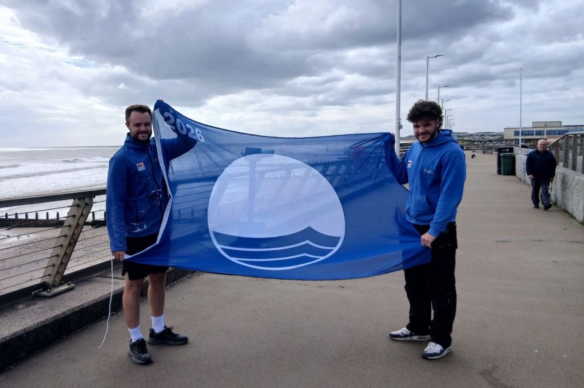Charlie Slater and Bailey Alves from East Riding of Yorkshire Council’s coastal services team with the 2026 Blue Flag in Hornsea