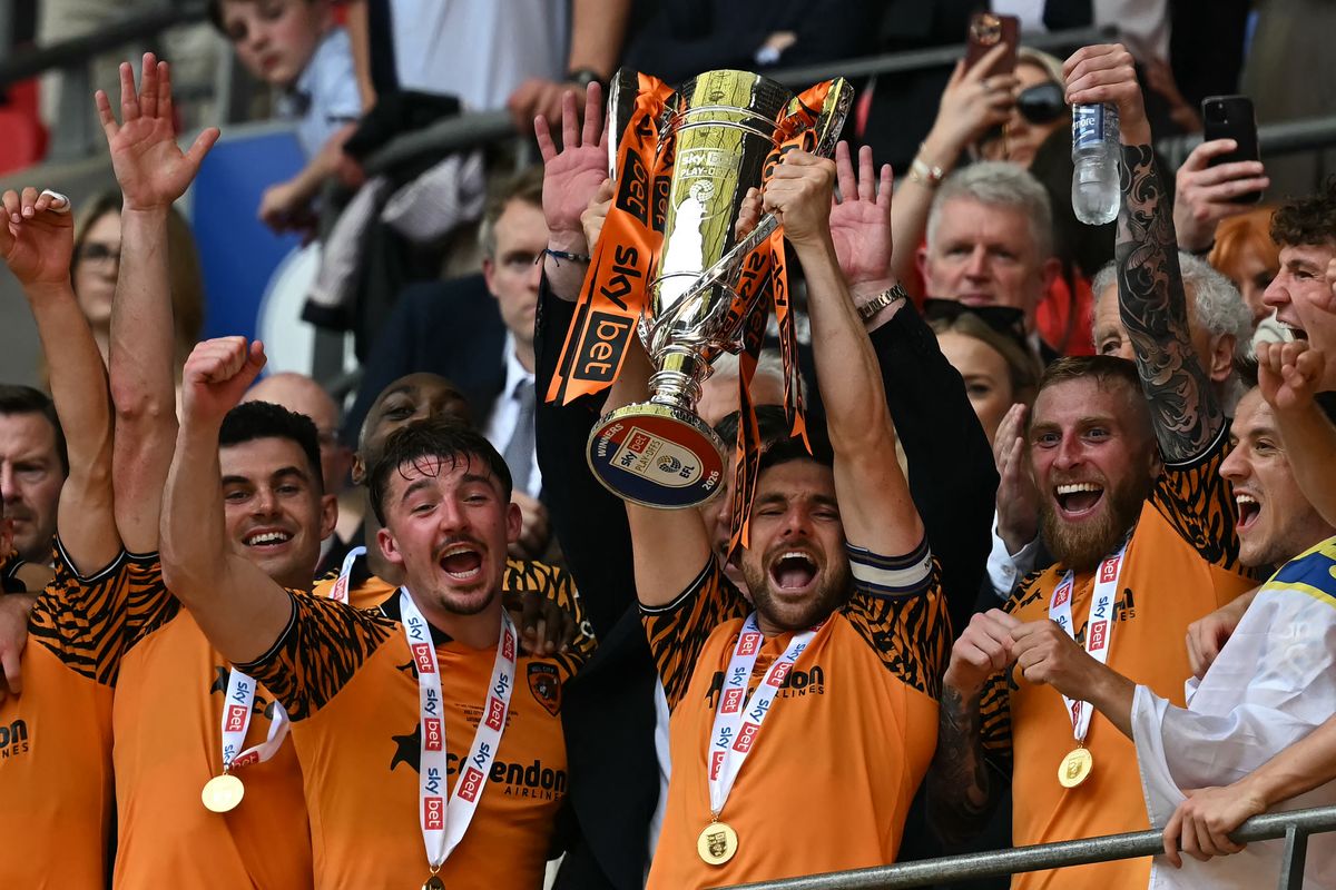 Hull City's Lewie Coyle lifting the Championship play-off final trophy