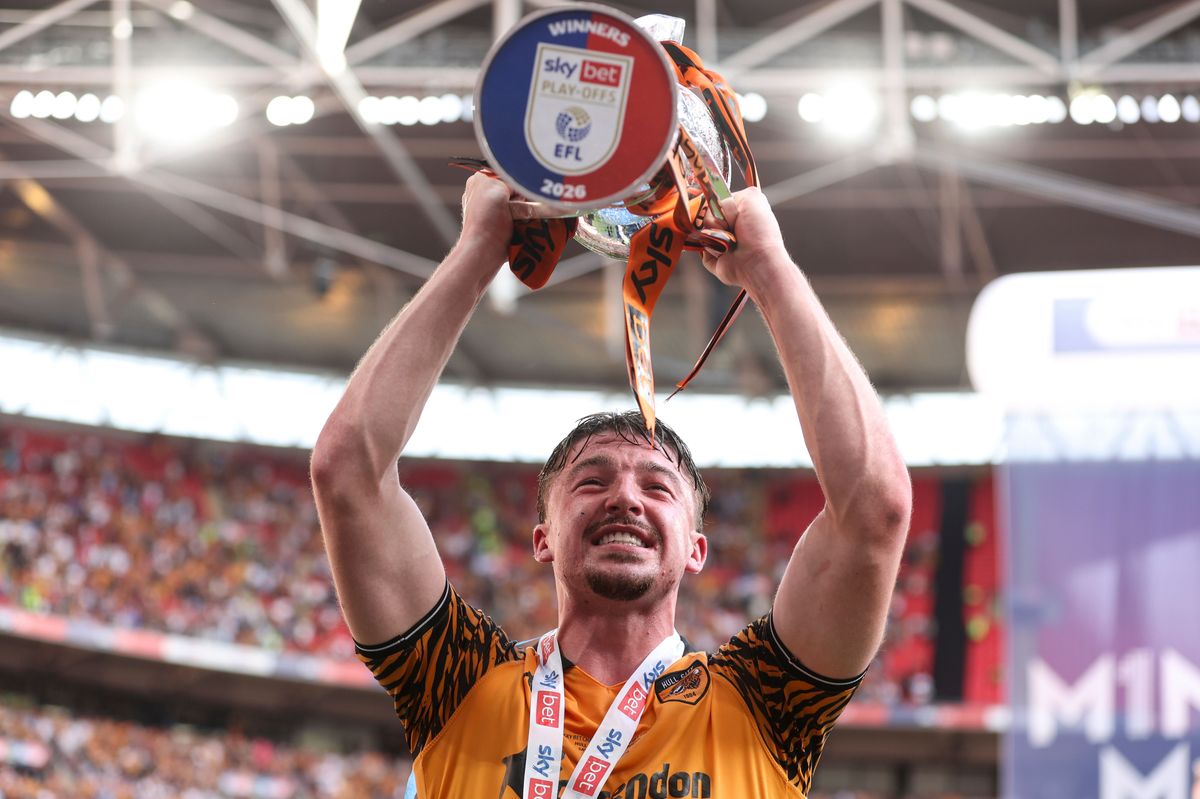 Charlie Hughes lifts the Championship play-off final trophy