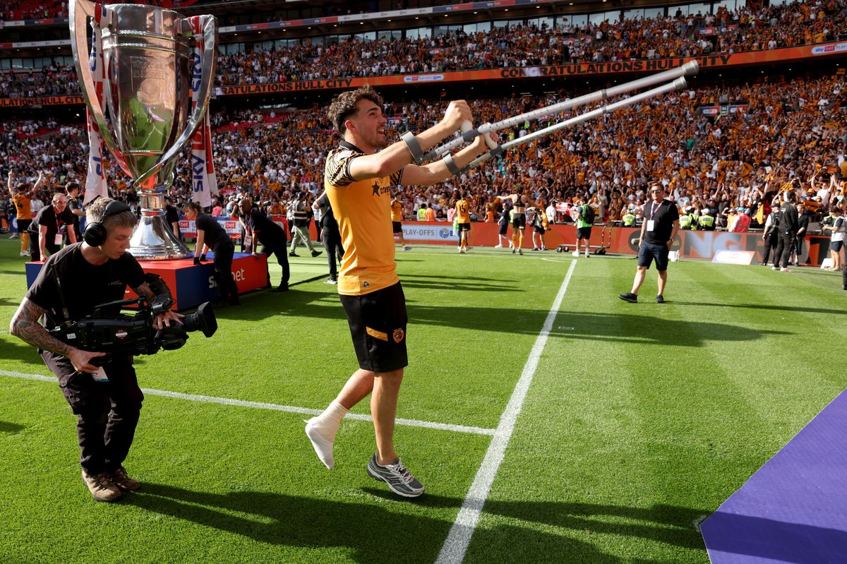Kyle Joseph on his crutches celebrates the win at Wembley Stadium