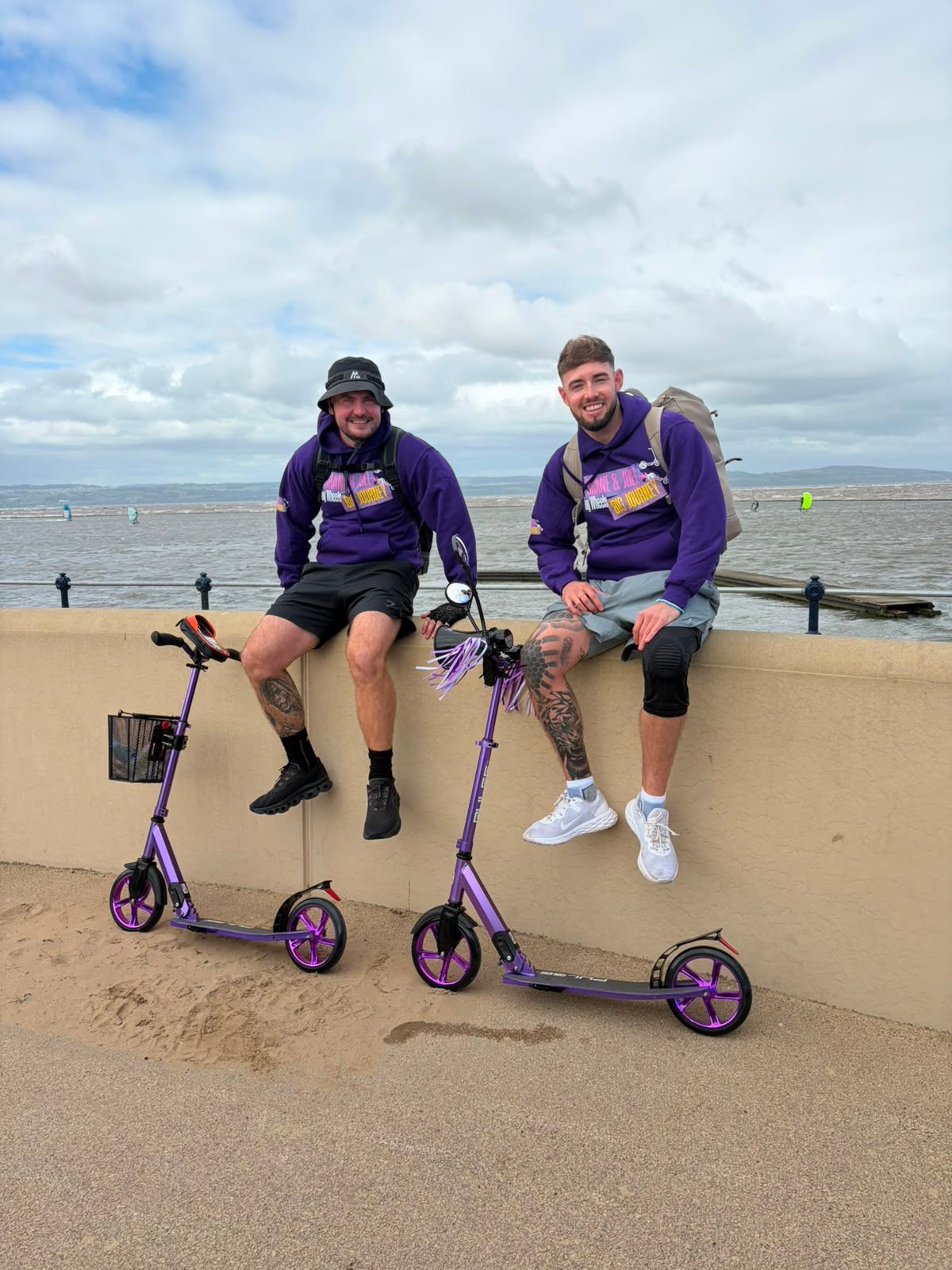 Joel and Shane on their way to Hull on two £60 scooters, pictured on a wall at West Kirby Beach