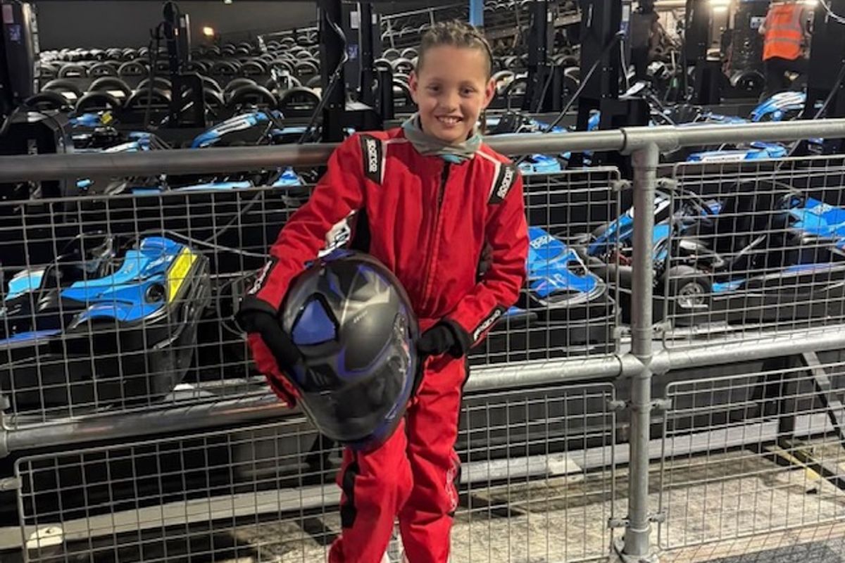 Nine-year-old Jaxon Na'ama after his win at the Hull Grid Series Championship on Monday holds his helmet and wears red racing suit