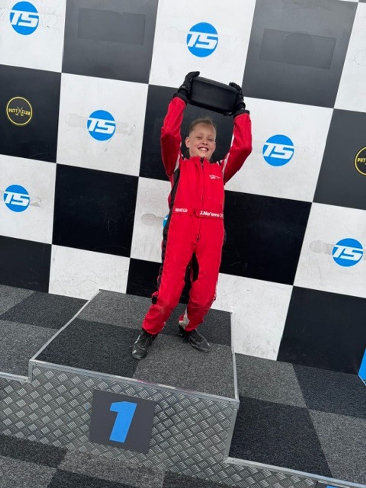 Jaxon Na'ama, 9, celebrates on the podium after becoming the Hull Grid Series Champion in karting at Teamsport in Hull