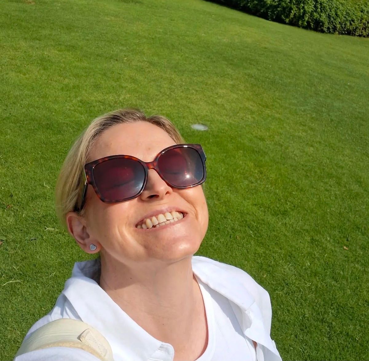 A selfie of Sarah Carr smiling with grass in the background