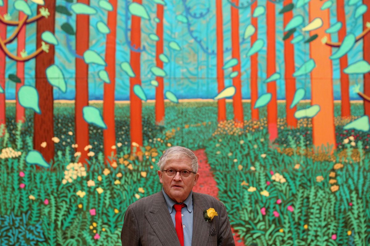 David Hockney, pictured in 2012, in front of his painting 'The Arrival of Spring in Woldgate, East Yorkshire in 2011'